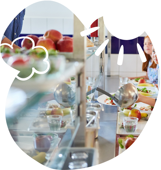 Food being served in a cafeteria with trays of salad, fruit, and drinks visible. A large ladle is serving food onto a plate. Children are seated in the background, eating at a table. Graphic elements of a sun and cloud overlay the image.